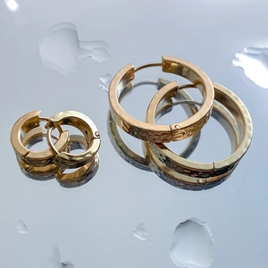 Orecchini a cerchio d'oro in acciaio inossidabile con texture lisce e martellate su specchi