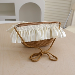 Detail of a sweet straw woven mini crossbody bag with cream satin ruffled ribbon trim