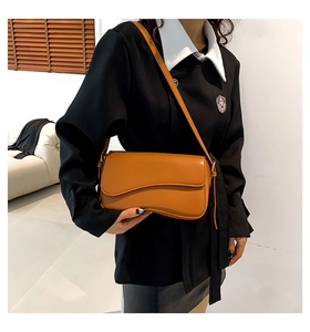 Brown PU leather crossbody bag featuring an asymmetric flap design on a female model