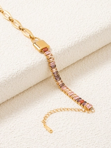 Dettaglio bracciale in oro 18k con gemme colorate e ciondolo a lucchetto 18KGP