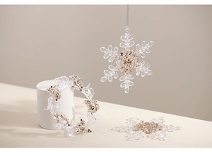Close-up of acrylic Christmas snowflake and ring ornament with champagne gold glitter