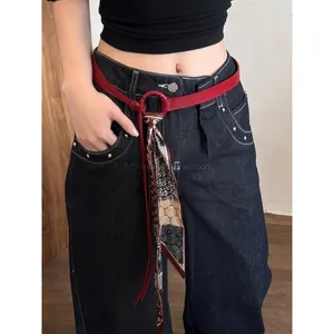Retro red leather belt with floral silk scarf accessory on high waist blue jeans