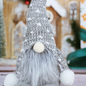 Close-up of Nordic Christmas gnome with grey knitted heart hat and faux fur beard