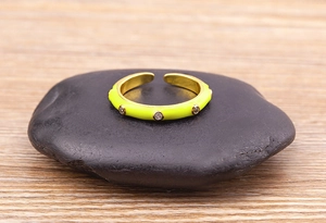 Detail of yellow enamel gold ring with micro-set zircons on a black stone base
