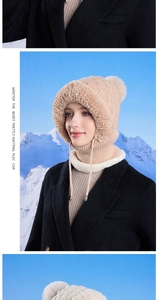 Detail of beige winter knit hat with white faux fur lining and top pompom on snowy background