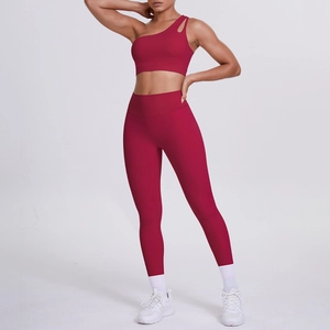 Detail of wine red one-shoulder sports bra and high-waist yoga leggings set on model