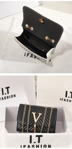 Detailed view of black V-quilted shoulder bag with gold metal logo and tassel accents