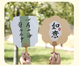 Detail of Chinese calligraphy hand fans with Zen quotes in a scenic outdoor garden setting
