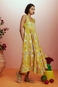 Robe longue d'été à imprimé paisley et sandales dans un décor de vacances bohème