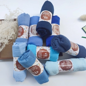 Close-up of pleated cotton viscose shawls in blue gradient with kraft paper bands