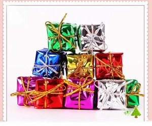 Macro shot of assorted colorful laser-finish Christmas tree gift box ornaments and decorations