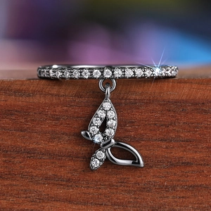 Macro shot of dark metal butterfly pendant ring with shimmering white zircon stones