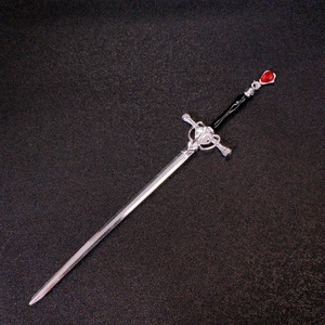 Detail of sword hair pin featuring a black handle and a red teardrop gemstone inlay