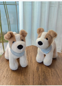 Close-up of cute plush Fox Terrier dogs with blue plaid scarves on a wooden table