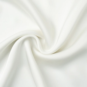 Close-up of white satin fabric with elegant pearl luster and silky smooth texture
