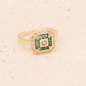 Detail of an adjustable gold ring featuring an emerald green zircon and round crystal