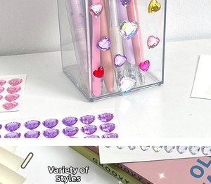 3D heart gemstone stickers shown applied to a transparent pen holder for decoration
