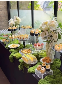 Forest theme dessert table display featuring thick artificial moss and elegant glass stands