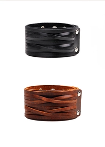 Detailed view of black and brown braided leather bracelets with metal snaps on white background