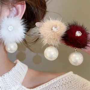 Macro detail of elegant pompom pearl earrings with sparkling zircon and gold-plated finish