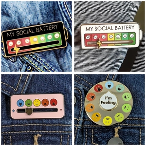 Rainbow mood wheel and social battery enamel pins set on blue denim fabric background
