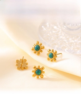 Detailed macro view of PVD plated 18k gold sunflower stud earrings with blue-green gemstone