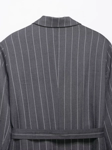 Detailed back view of a grey striped suit jacket with adjustable waist tie and sharp texture