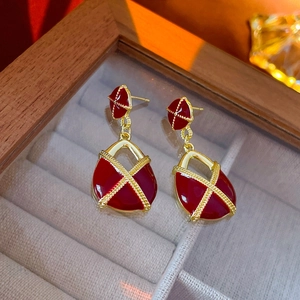 Gros plan sur boucles d'oreilles vintage en émail rouge avec bordures dorées