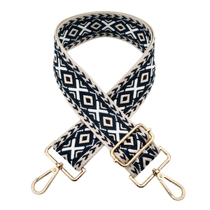 Close-up of geometric diamond pattern strap with golden metal swivel hooks for handbags