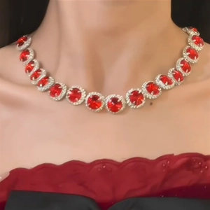 Close-up of elegant silver necklace with red round gemstones and zircon halo on neck