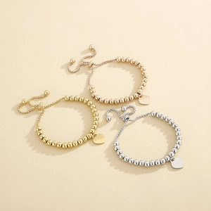 Three-piece stainless steel beaded bracelets in gold, silver, and rose gold with heart charms