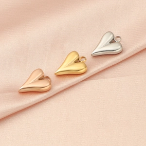 Polished stainless steel heart pendants in gold, rose gold and silver on pink silk fabric