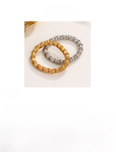Detail view of twisted gold and silver titanium steel bangles with textured finish