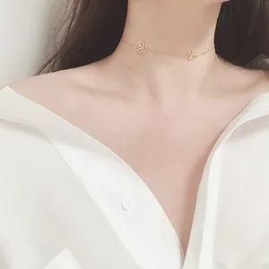Detailed view of elegant gold camellia flower pendants on a delicate choker necklace