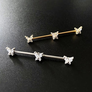 Detail of industrial barbell earrings with sparkling butterfly crystal marquise stones