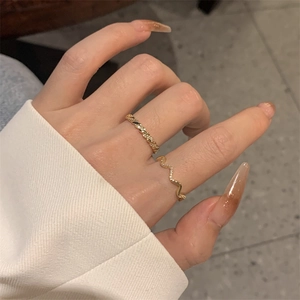 Detail of gold plated twisted and wave rings with cubic zirconia for stacked women jewelry