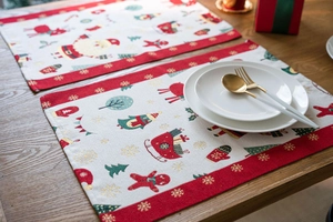 Detailed view of woven Christmas placemat with Santa Claus and reindeer on a wooden table