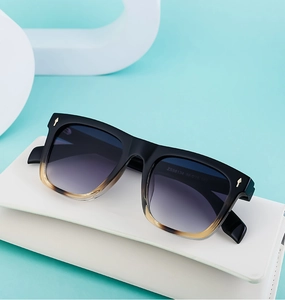 Detail of square vintage sunglasses with metallic arrow rivets on the gradient frame