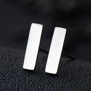 Close-up of minimalist rectangular bar stud earrings in polished stainless steel silver