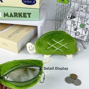 Detail of plush green turtle coin purse showing soft texture and silver ball chain hook