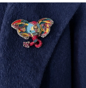 Macro view of colorful enamel elephant brooch with rhinestones on a navy blue coat