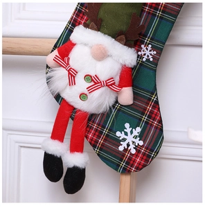 Detail of red and green plaid Christmas stocking with a 3D Santa Claus plush character