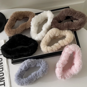 Detailed close-up of fluffy faux fur hair scrunchies in seven various neutral earth tones