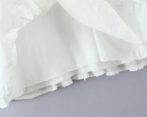 Detail van de witte bloemen geborduurde kantstof en de zachte binnenvoering