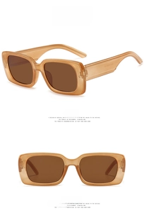 Detail view of retro square sunglasses featuring translucent amber frames and brown lenses