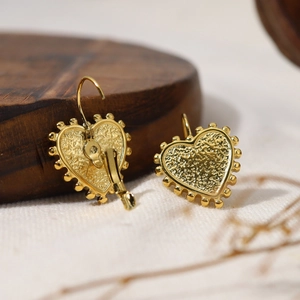 Detail of 18k gold heart hoop earrings with vintage hammered texture and beaded edges