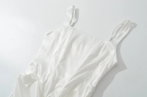Gros plan détaillé montrant la texture lisse et le fini brillant du tissu en satin blanc