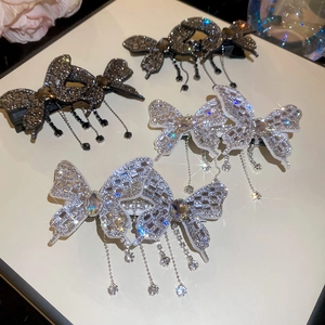 Detailed macro view of butterfly hair clips with sparkling rhinestone tassel pendants