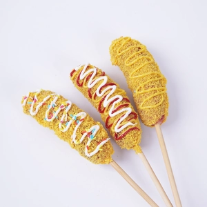 Three crispy fried corn dogs with colorful sprinkles and sauce on a clean white background