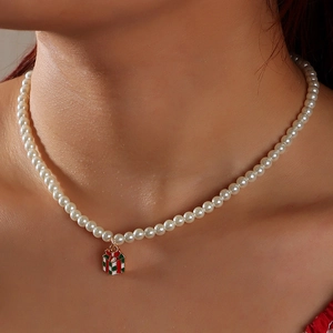 Detail of Christmas pearl necklace with festive red and green gift box pendant on model
